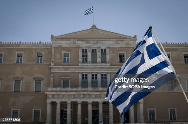 Greek flag seen front of the Greek Parliament at the demonstration. People demonstrated in Syntagma square, Athens, in protest at the Greek...