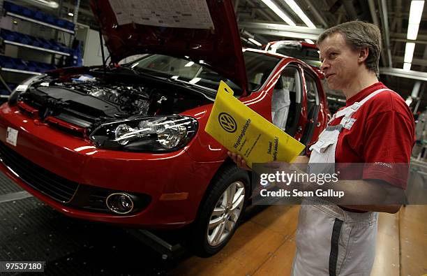 Worker checks paperwork for a Volkswagen Golf VI car on the assembly line at the VW factory on March 8, 2010 in Wolfsburg, Germany. Volkswagen will...