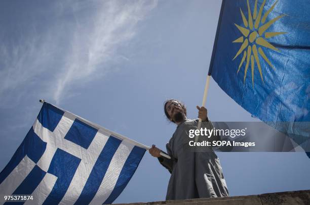 Priest seen holding Greek and Macedonia flags front of Greece Parliament at the demonstration. People demonstrated in Syntagma square, Athens, in...