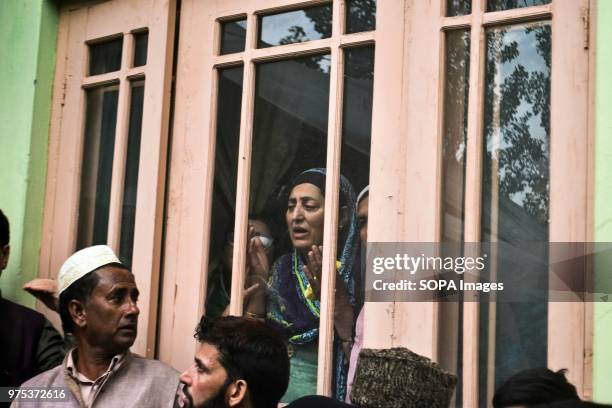 Woman prays during the funeral procession of Shujaat Bukhari, veteran journalist and Editor-in-Chief of English daily 'Rising Kashmir,' in Kreeri,...