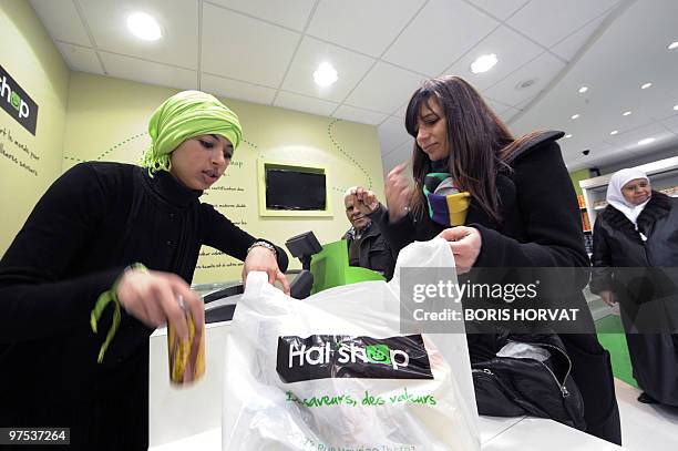 People pay their food at the cashier at "Hal' shop", a supermarket selling halal food, in Nanterre, a Paris suburb, where they bought food some hours...