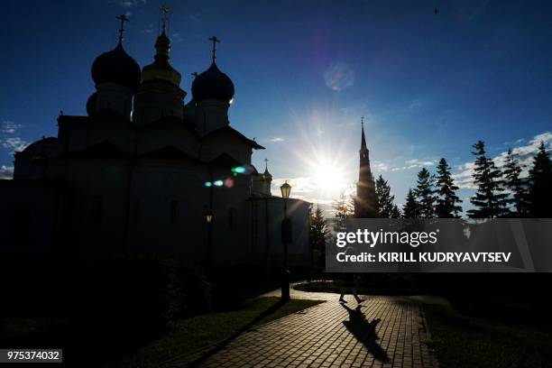 Woman walks in front of Annunciation Cathedral and Suyumbike historical tower in the Kazan Kremlin in central Kazan on June 15 during of the Russia...