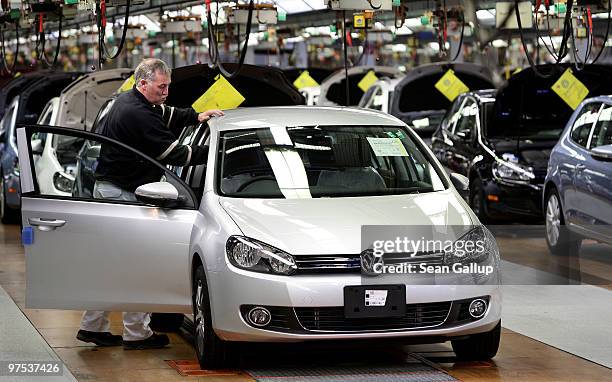 Worker prepares finished Volkswagen Golf cars to be driven off the end of the assembly line at the VW factory on March 8, 2010 in Wolfsburg, Germany....