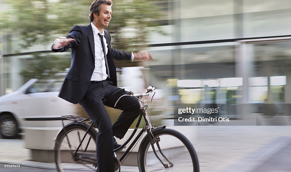 Man riding bike and letting go of the handle bars