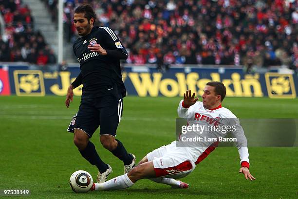 Hamit Altintop of Muenchen is challenged by Lukas Podolski of Koeln during the Bundesliga match between 1. FC Koeln and FC Bayern Muenchen at...