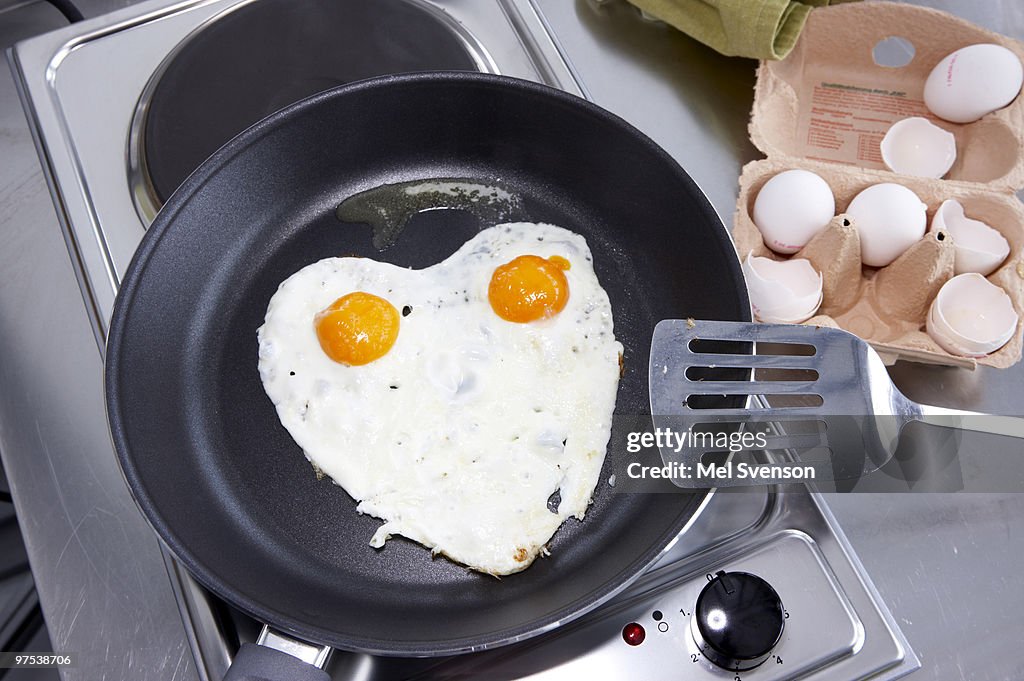 Heart shaped fried eggs in a pan, Sunny side up 