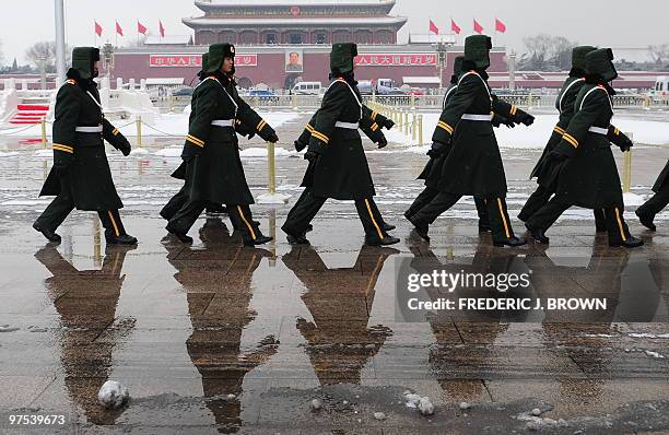 Chinese paramilitary police cast a reflection on the ground while marching on Tianamen Square ahead of a session at the ongoing National People's...