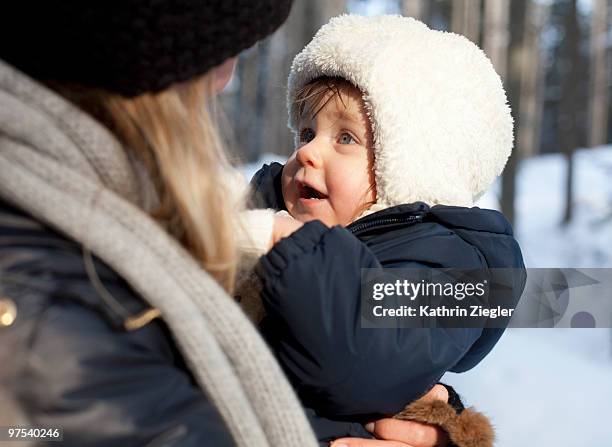 woman holding babygirl in winter clothes - kathrin ziegler stockfoto's en -beelden