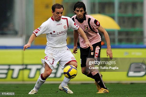 Antonio Filippini of Livorno and Javier Pastore of Palermo compete for the ball during the Serie A match between US Citta di Palermo and AS Livorno...