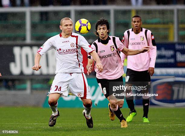 Javier Pastore of US Citta' di Palermo battles for the ball with Santos Batista Junior Mozart of AS Livorno Calcio during the Serie A match between...