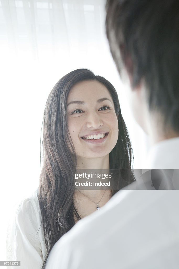 A couple face each other, smiling