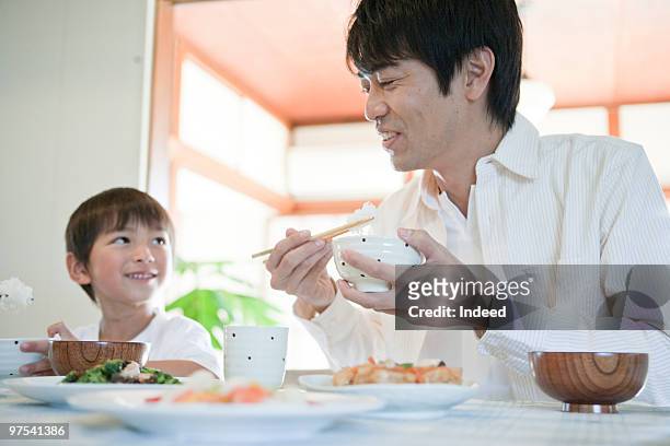 father and son eating japanese breakfast, smiling - 日本食 個照片及圖片檔