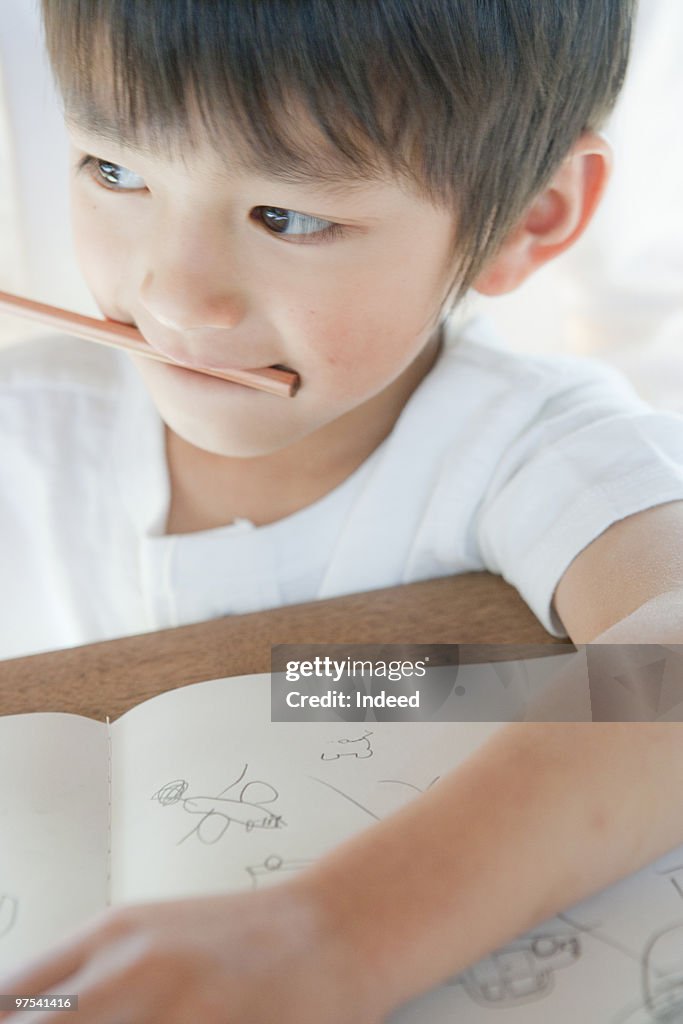 A boy(4-5) biting pencil, close-up