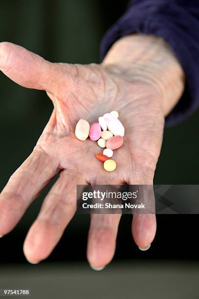 pills in a senior citizen's hand - shana novak imagens e fotografias de stock