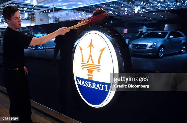 An employee cleans a Maserati logo prior to the official opening of the Geneva International Motor Show in Geneva, Switzerland, on Monday, March 1,...