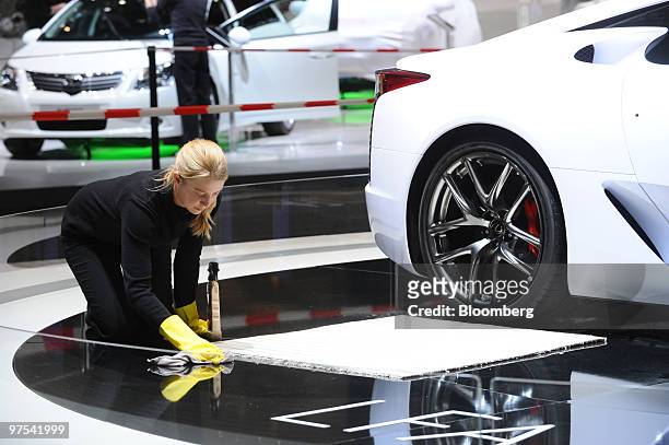 An employee cleans the Lexus stand prior to the official opening of the Geneva International Motor Show in Geneva, Switzerland, on Monday, March 1,...
