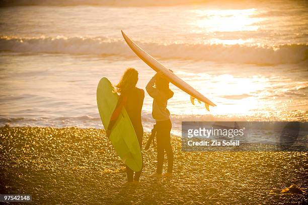 mom and daughter about to go surfing together - surf souleil stock-fotos und bilder