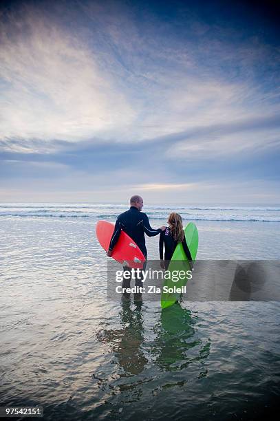 father and daughter going surfing together - surf souleil stock-fotos und bilder