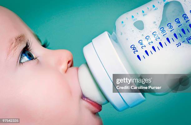 baby drinking milk (or formula) from a baby bottle - baby bottle stockfoto's en -beelden