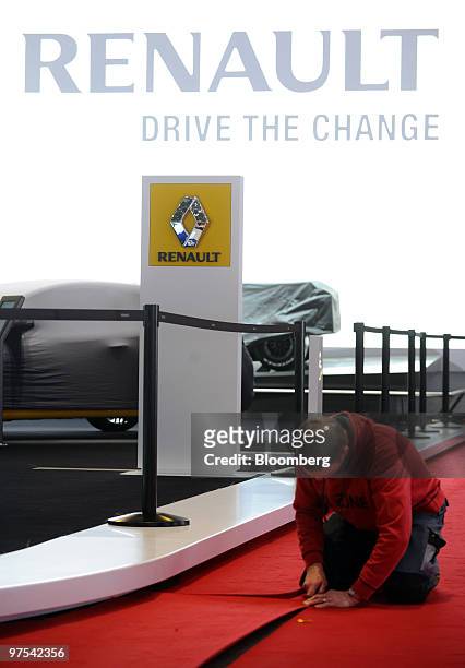 An employee cleans the Renault stand prior to the official opening of the Geneva International Motor Show in Geneva, Switzerland, on Monday, March 1,...