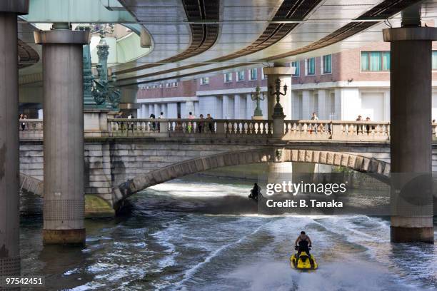 jet skis and nihonbashi bridge in tokyo - nihonbashi tokyo stock pictures, royalty-free photos & images