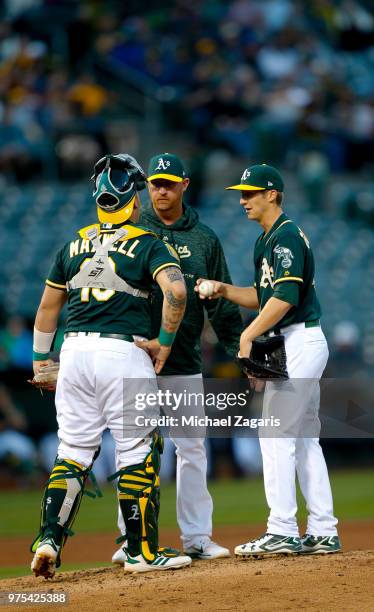 Bruce Maxwell, Pitching Coach Scott Emerson and Daniel Gossett of the Oakland Athletics talk on the mound during the game against the Tampa Bay Rays...