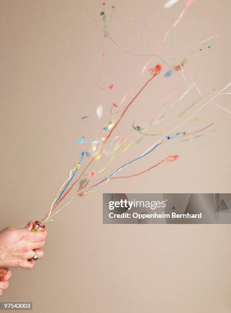 hand pulling string of party popper - party poppers stock pictures, royalty-free photos & images