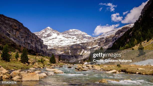 river in snow covered mountains, ordesa y monte perdido national park, huesca, spain - parco nazionale di ordesa foto e immagini stock