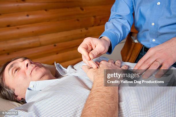 acupuncturist putting needle in patient's hand - manchester vermont foto e immagini stock