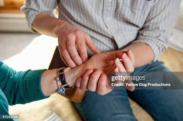 close up of therapist taking patient's pulse - manchester vermont foto e immagini stock