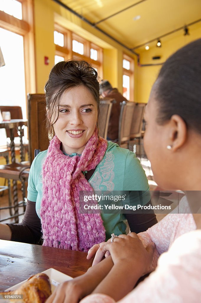 Two women sitting together in coffee shop 