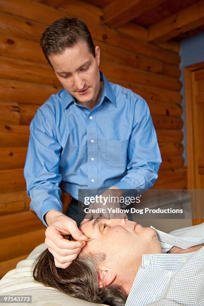 acupuncturist putting needle in patient's face - manchester - vermont imagens e fotografias de stock