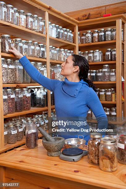 herbalist reaching for jar of herbs - manchester vermont foto e immagini stock