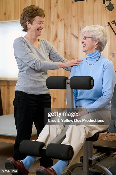 physical therapist helping patient - physical position - fotografias e filmes do acervo