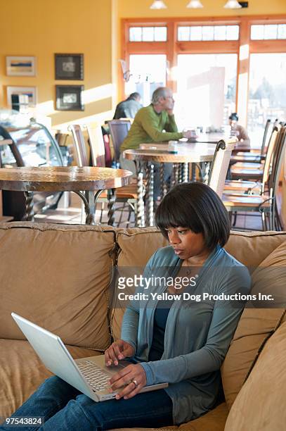 woman working on computer in coffee shop - manchester vermont foto e immagini stock