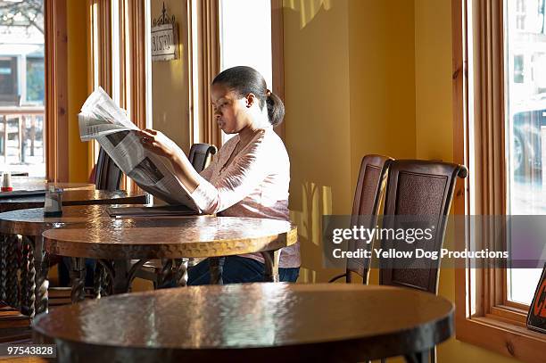woman reading newspaper in coffee shop - manchester - vermont imagens e fotografias de stock