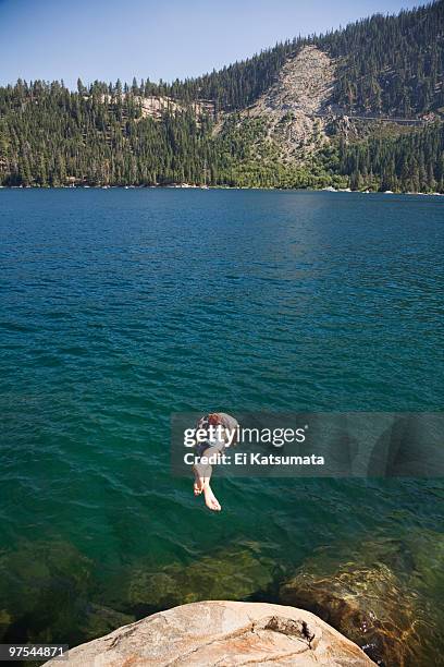 young man diving off of a rock into lake tahoe - emerald bay lake tahoe stock pictures, royalty-free photos & images