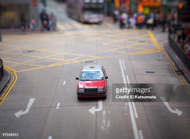 red taxicab in the middle lane of a one way street - ei 個照片及圖片檔