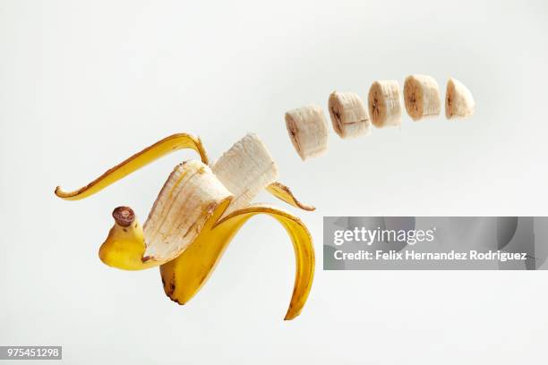 partially sliced banana mid-air - food flying stock-fotos und bilder