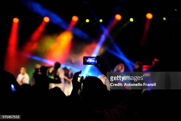 woman photographing in pop concert, sardinia, italy - pop reggae stock pictures, royalty-free photos & images