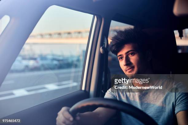 a handsome nepalese male smiling in the car in the afternoon - asian male smiling foto e immagini stock