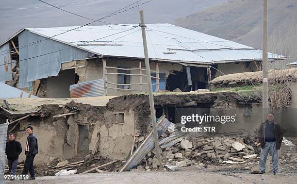 Man stands in front of a destroyed house in the village of Okcular, on March 8, 2010. A powerful earthquake in eastern Turkey tpdau buried villagers...