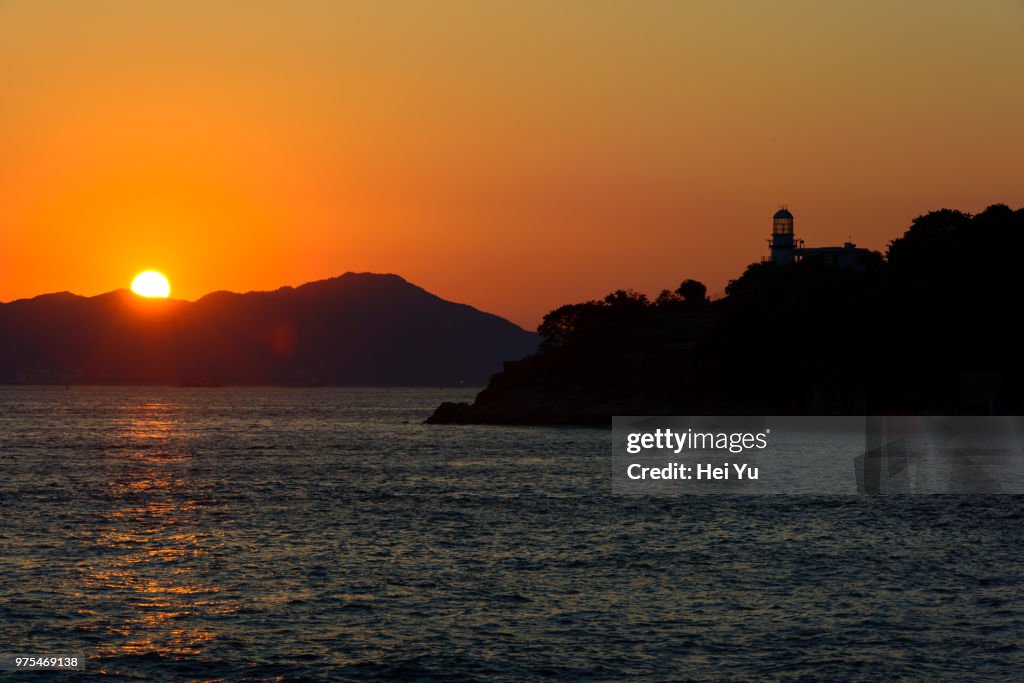 Silhouettes of islands and lighthouse at sunset, Hong Kong