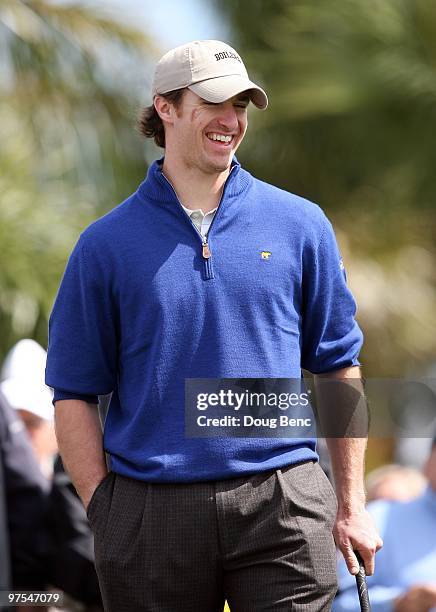 Super Bowl winning quarterback Drew Brees of the New Orleans Saints smiles to the cheers from the crowd before teeing off on the first hole during...