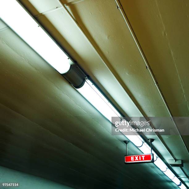 exit sign - luce fluorescente foto e immagini stock