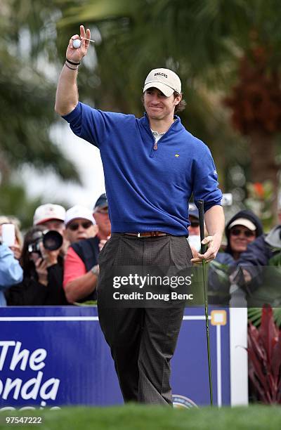 Super Bowl winning quarterback Drew Brees of the New Orleans Saints acknowledges the cheers from the crowd before teeing off on the first hole during...