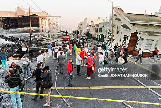 Firefighters extinguish fire in the Marina District in San Francisco 21 October 989 after a quake erupted 17 October in the city, killing an...