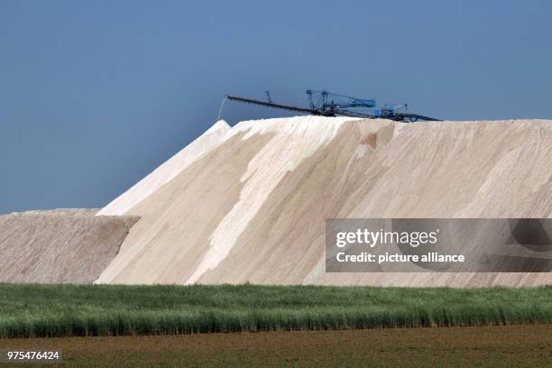 May 2018, Germany, Loitsche: The 100 metres high spoil heap rises above the small town of Loitsche. Zielitzer Kali AG stores residues which contain...