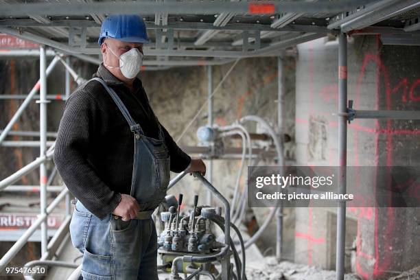 May 2018, Germany, Koenigswinter: A worker placing steel enforcements into the stones under the Drachenfels castle. Workers are placing ground...