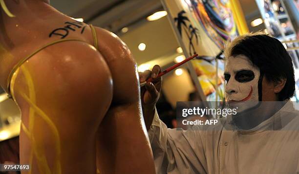 Argentina's artist McPyo paints the body of a model during the 6th International Tattoo Show in Buenos Aires on March 7, 2010. The exhibition draws...